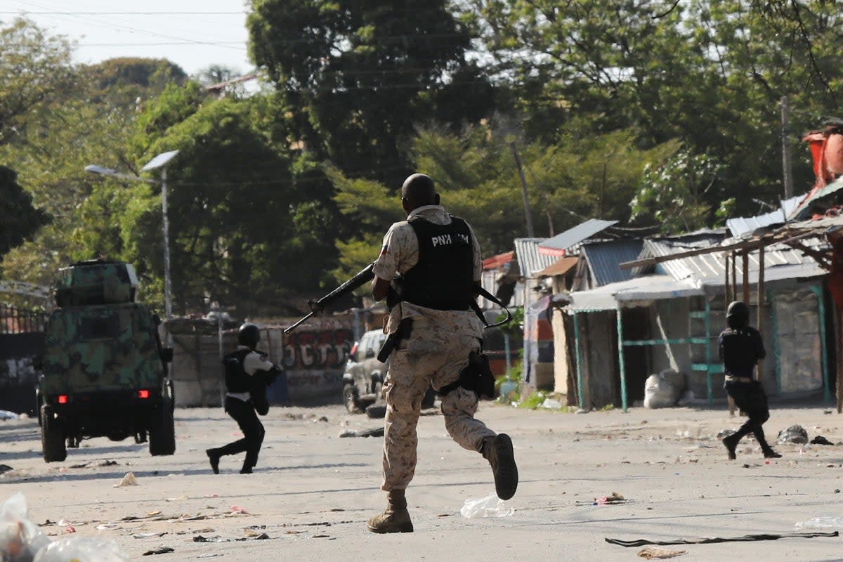 Police officers run holding their guns while confronting a gang during a protest against Prime Minister Ariel Henry's government and insecurity, in Port-au-Prince, Haiti 1 March 2024 (REUTERS)
