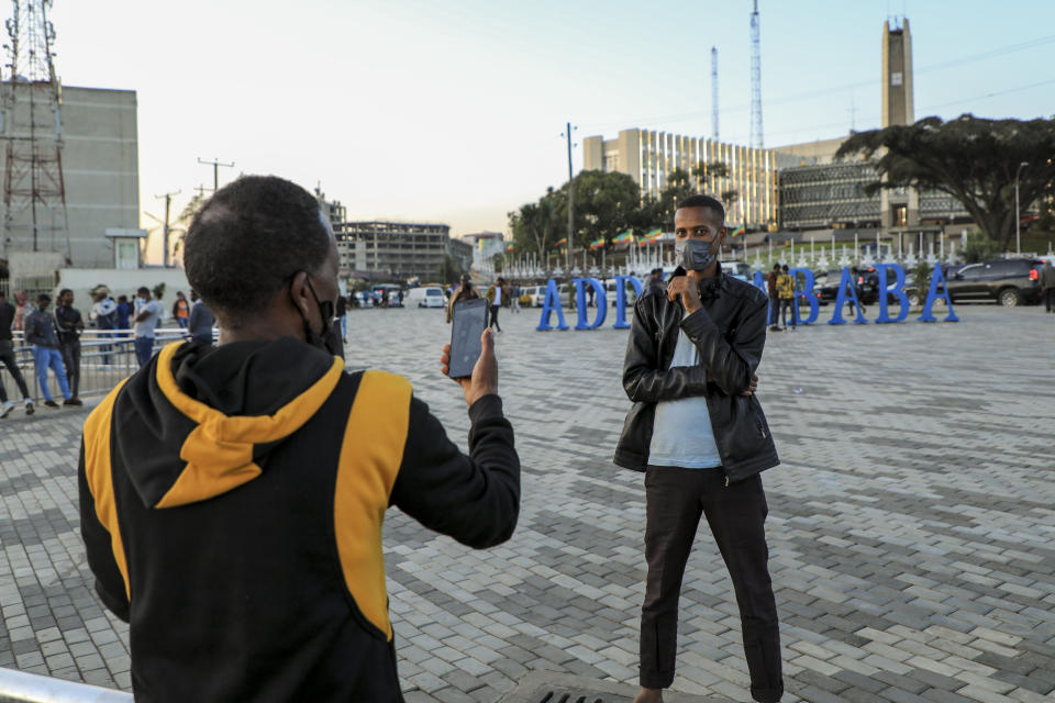 A man poses to have his photograph taken in front of a sculpture in the shape of the words "Addis Ababa" in the Piazza old town area of the capital Addis Ababa, Ethiopia Thursday, Nov. 4, 2021. Urgent new efforts to calm Ethiopia's escalating war are unfolding Thursday as a U.S. special envoy visits and the president of neighboring Kenya calls for an immediate cease-fire while the country marks a year of conflict. (AP Photo)