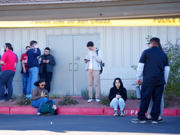 People wait on the outskirts of the UNLV campus after a shooting on 6 December 2023 in Las Vegas, Nevada (Getty Images)