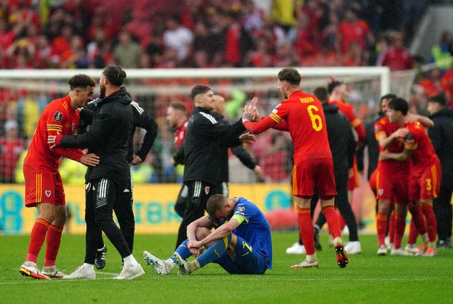 Ukraine’s Andriy Yarmolenko sits dejected on the turf as Wales celebrate victory