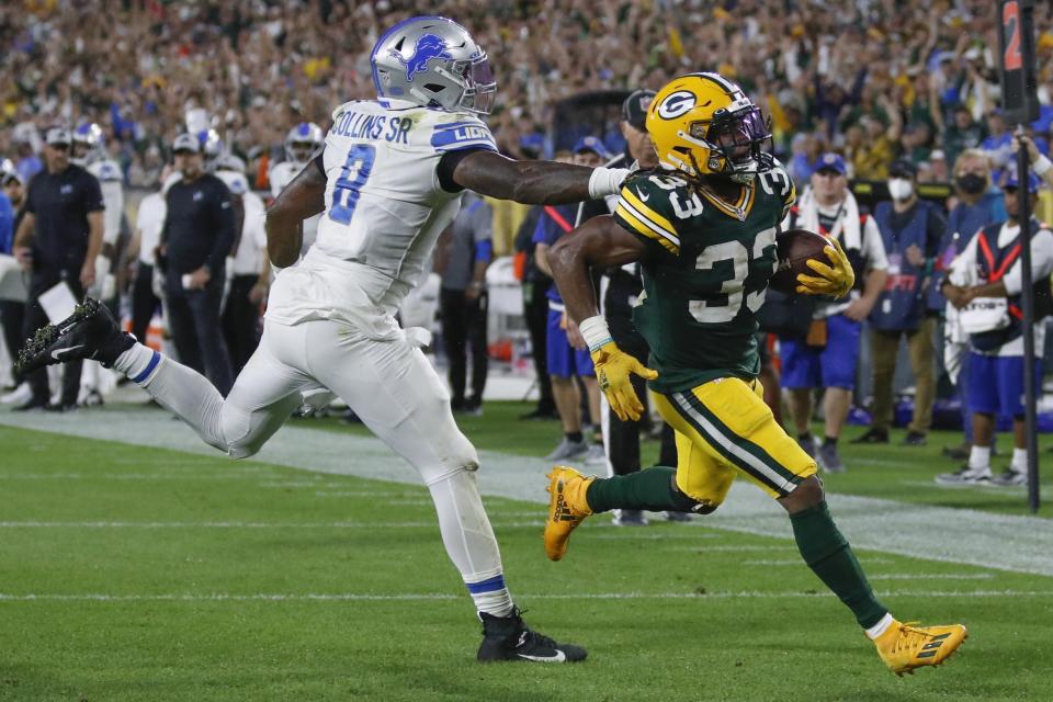 Aaron Jones de los Packers de Green Bay supera a Jamie Collins de los Lions de Detroit para un touchdown, el lunes 20 de septiembre de 2021, en Green Bay, Wisconsin. (AP Foto/Matt Ludtke)