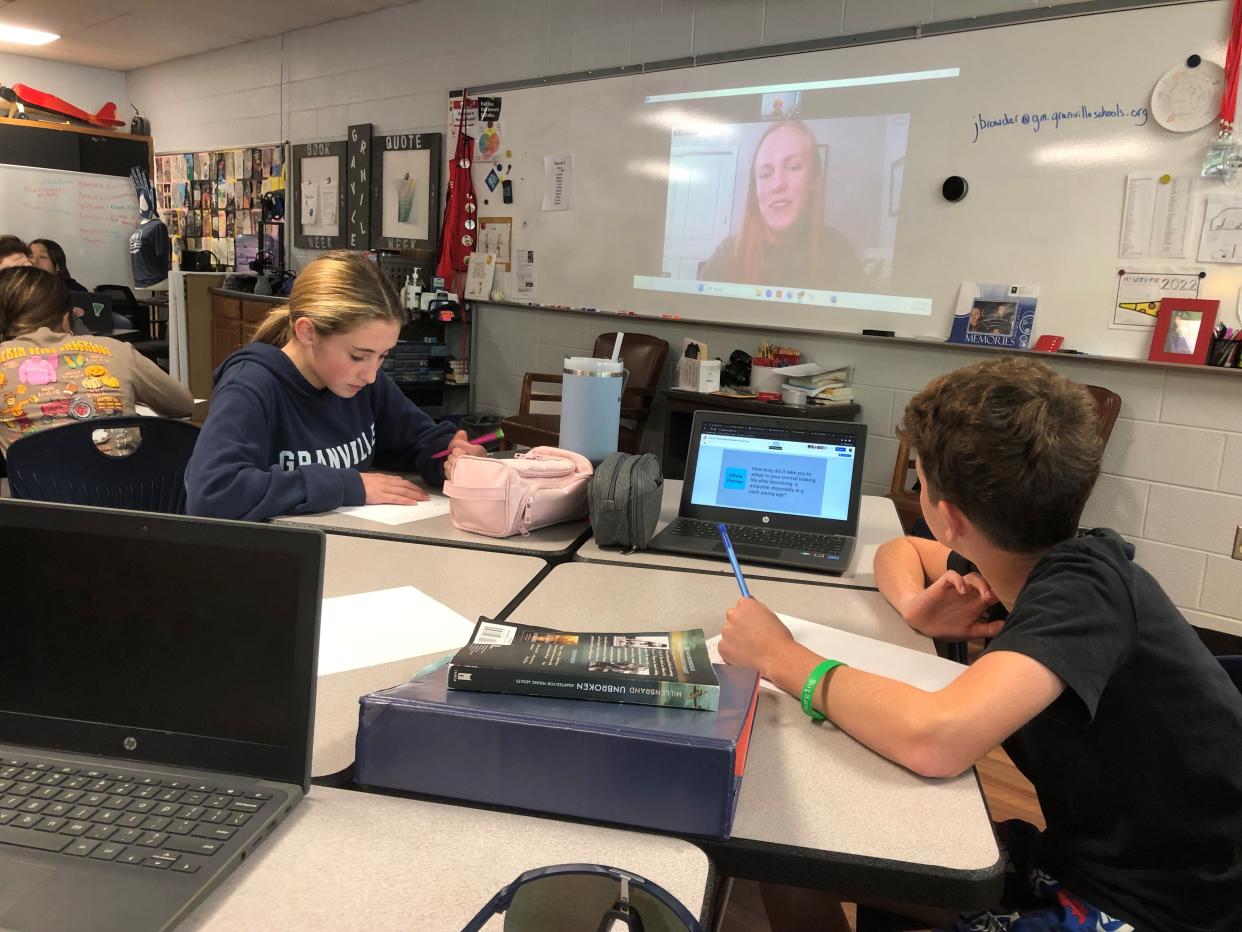 Devon Davidoff, left, and Connor Boissy take notes as two-time Paralympic discus thrower Jessica Heims speaks to their seventh-grade English language arts class via Zoom on Oct. 6 at Granville Middle School. The class interviewed Heims, who had her left leg amputated below the knee, as a way to further connect with a book students read over the summer, "The Running Dream," a fiction novel about a girl who loses a leg in a car crash and learns to run again.