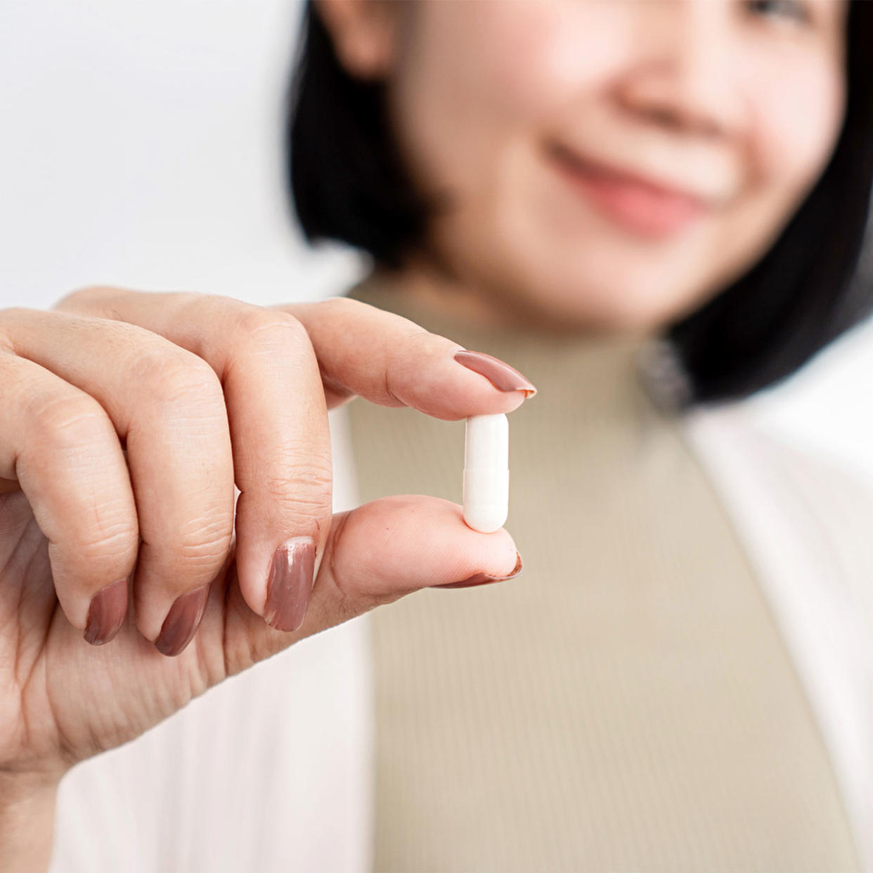 woman holding up a probiotic