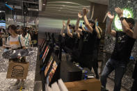 Workers cheer as the first customer pose for photos with gifts at the opening of the first Beijing outlet for Shake Shack in Beijing on Wednesday, Aug. 12, 2020. The U.S. headquartered burger chain is opening its first Beijing restaurant at a time when China and the U.S. are at loggerheads over a long list of issues. (AP Photo/Ng Han Guan)