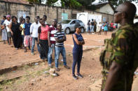 A military member stands guard as people queue to cast their vote during a presidential run-off in Freetown, Sierra Leone March 31, 2018. REUTERS/Olivia Acland