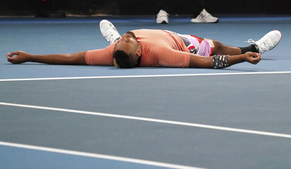 Australia's Nick Kyrgios lies on the court as he celebrates after defeating Russia's Karen Khachanov in their third round singles match at the Australian Open tennis championship in Melbourne, Australia, Saturday, Jan. 25, 2020. (AP Photo/Lee Jin-man)