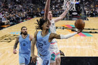 Memphis Grizzlies guard Ja Morant (12) drives to the basket against San Antonio Spurs center Jakob Poeltl (25) during the second half of an NBA basketball game, Wednesday, Jan. 26, 2022, in San Antonio. (AP Photo/Eric Gay)