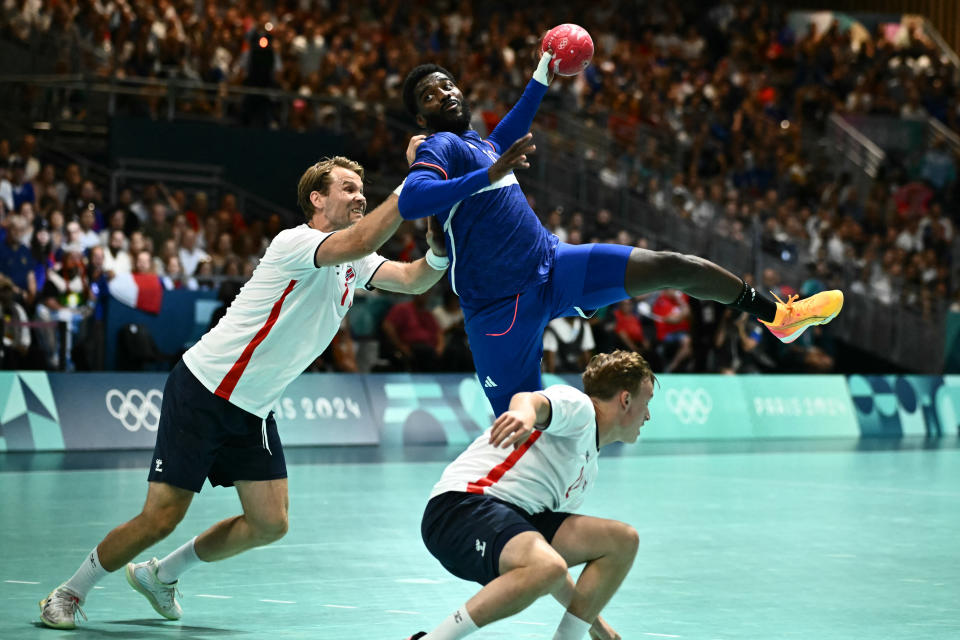 France's right back #10 Dika Mem (C) attempts to score  during the Men's Preliminary Round Group B handball match between France and Norway of the Paris 2024 Olympic Games, at the Paris South Arena in Paris, on July 29, 2024. (Photo by Aris MESSINIS / AFP) (Photo by ARIS MESSINIS/AFP via Getty Images)