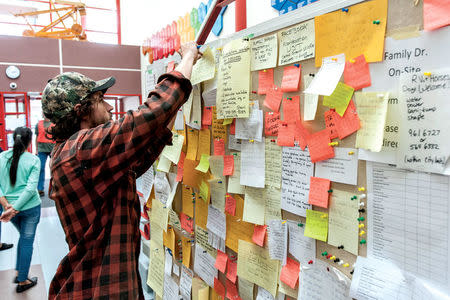 Rob Robinson of Salmon Valley, 26 kilometres north of Prince George, finds an open spot on the bulletin board to pin his notice offering space for wildfire evacuees to camp on his land, at the College of New Caledonia's Emergency Reception Centre in Prince George, British Columbia, Canada July 10, 2017. REUTERS/Chuck Nisbett