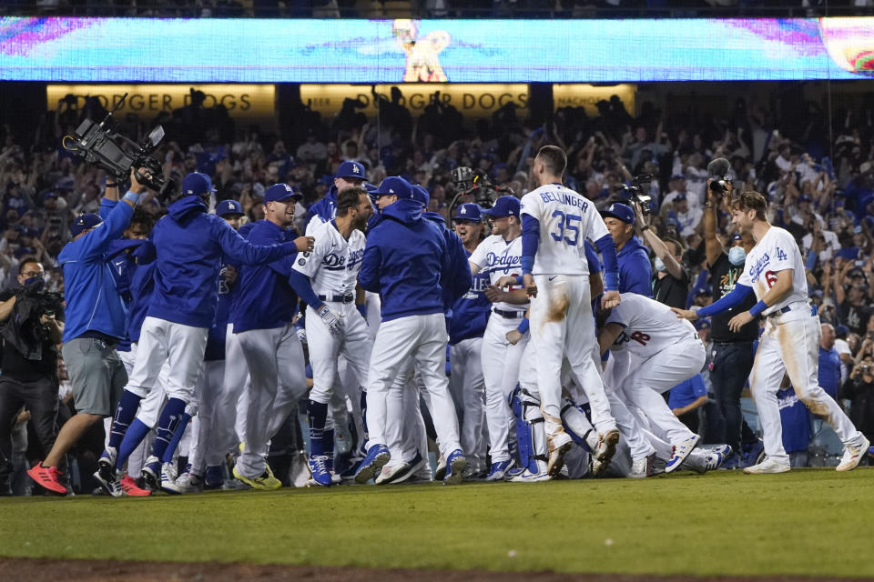 The Los Angeles Dodgers celebrate with Chris Taylor (3) after he hit a home run during the ninth inning to win a National League Wild Card playoff baseball game 3-1 over the St. Louis Cardinals Wednesday, Oct. 6, 2021, in Los Angeles. Cody Bellinger also scored. (AP Photo/Marcio Jose Sanchez)