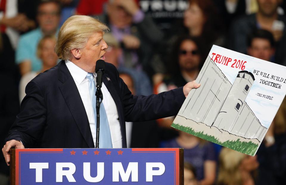 Then-presidential candidate Donald Trump holds a sign supporting his plan to build a wall between the United States and Mexico in Fayetteville, North Carolina March 9, 2016. (Photo: REUTERS/Jonathan Drake)