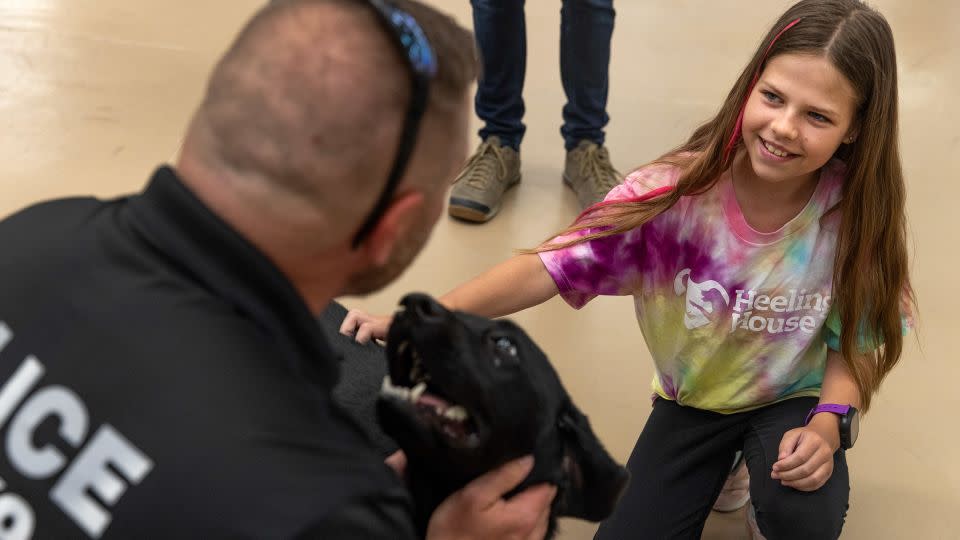 Alana Blanc, 12, pets detection dog Tara. - Tristen Rouse/CNN