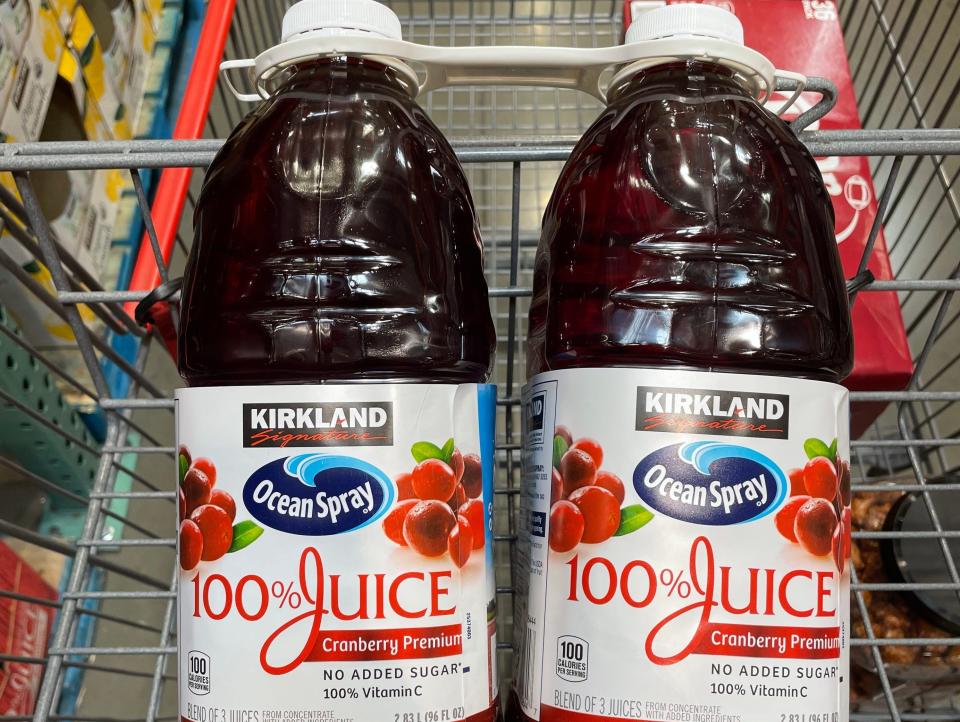 two bottles of cranberry juice in a cart at costco