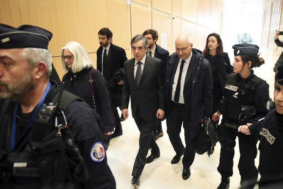 France's former Prime Minister Francois Fillon, center, and his wife Penelope, leave the Paris courthouse, in Paris, Monday, Feb. 24, 2020. He could have been president of France. Instead, former Prime Minister Francois Fillon is going on trial to face fraud charges after he used public funds to richly pay his wife and children for work they allegedly never performed. (AP Photo/Thibault Camus)