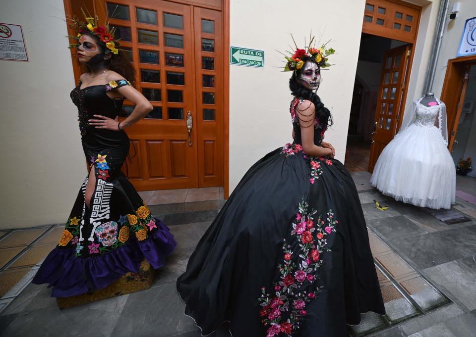 Models display dresses with Day of the Dead motifs designed by vendors of bridal and teenager dresses in downtown Mexico City on October 28, 2021.