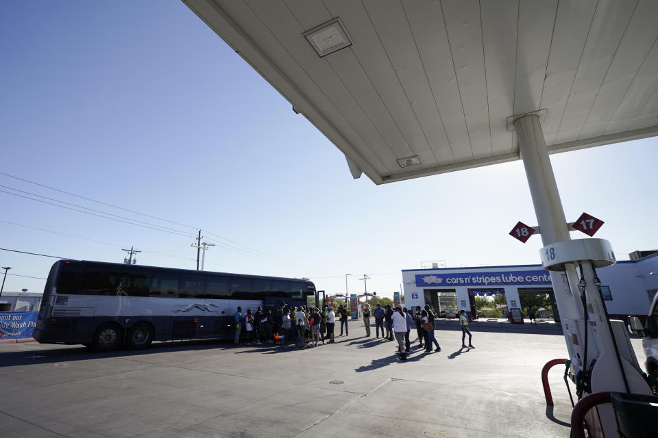 A bus picks up travelers, mostly migrants from Haiti released from A U.S. Customs and Border Protection custody, at a gas station that serves as a bus terminal, Thursday, Sept. 23, 2021, in Del Rio, Texas. Migrants released are greeted by a humanitarian organization, which facilitates bus tickets to San Antonio as they continue their journey. (AP Photo/Julio Cortez)