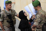 Lebanese soldiers ban an angry depositor to enter a bank during a protest, in Beirut, Lebanon, Friday, Sept. 24, 2021. Dozens of Lebanese depositors protested throwing eggs and tomatoes on a number of private banks in central Beirut, demanding to have access to their deposits which have been blocked under informal capital controls since the country's financial and economic crisis began in late 2019. (AP Photo/Hussein Malla)