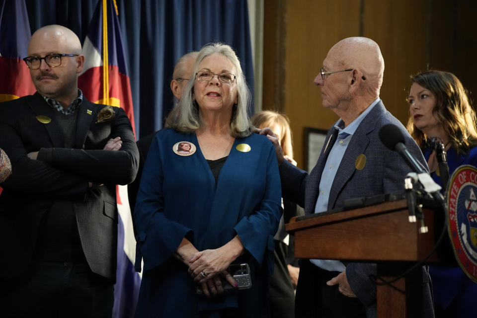 Sandy and Lonnie Phillips, who lost their daughter in the mass shooting at a theatre in Aurora, Colo., look on before Colorado Gov. Jared Polis signs four gun control bills into law during a ceremony, Friday, April 28, 2023, in the State Capitol in Denver. (AP Photo/David Zalubowski)
