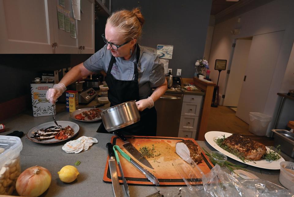 Erin Anderson, owner of Gather Provisions in Northborough, prepares a pork loin dish.