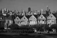 The "Painted Ladies" Victorian homes sit with the skyline in the background in San Francisco on May 7, 2020. Normally, the months leading into summer bring bustling crowds to the city's famous landmarks, but this year, because of the coronavirus threat they sit empty and quiet. Some parts are like eerie ghost towns or stark scenes from a science fiction movie. (AP Photo/Eric Risberg)