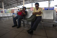 Passengers wait for their passenger van at a station in Tapachula, Mexico, Thursday, Jan. 19, 2023. There’s a police vehicle parked daily at the local station in Tapachula where vans arrive and depart constantly, but their drivers remain exposed to the activities of Central American street gangs that have moved operations into southern Mexico. (AP Photo/Moises Castillo)