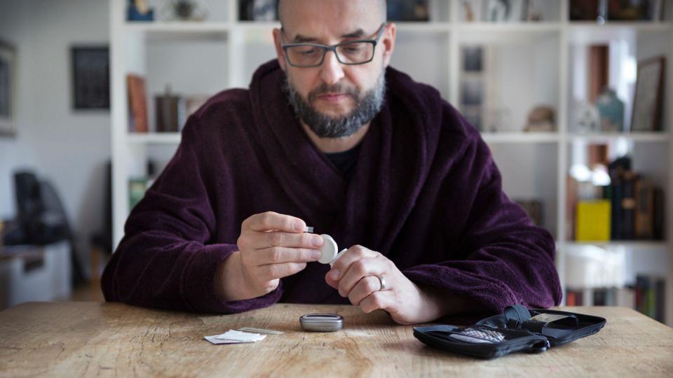 Un hombre mira un frasco de medicamentos 