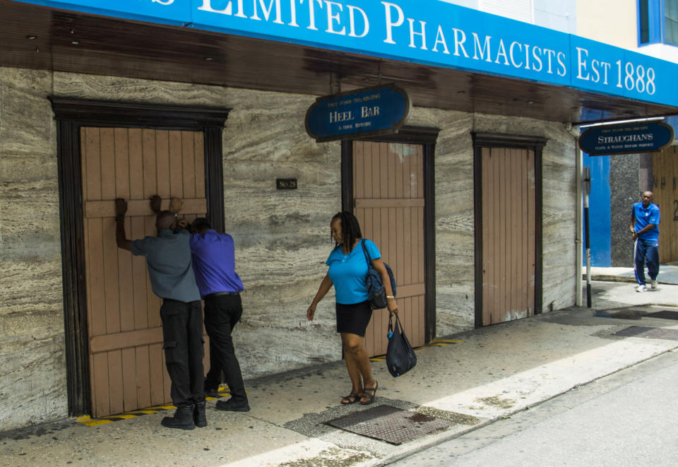 Residents board up a storefront pharmacy as they prepare for the arrival of Tropical Storm Dorian, in Bridgetown, Barbados, Monday, Aug. 26, 2019. Much of the eastern Caribbean island of Barbados shut down on Monday as Dorian approached the region and gathered strength, threatening to turn into a small hurricane that forecasters said could affect the northern Windward islands and Puerto Rico in upcoming days. (AP Photo/Chris Brandis)