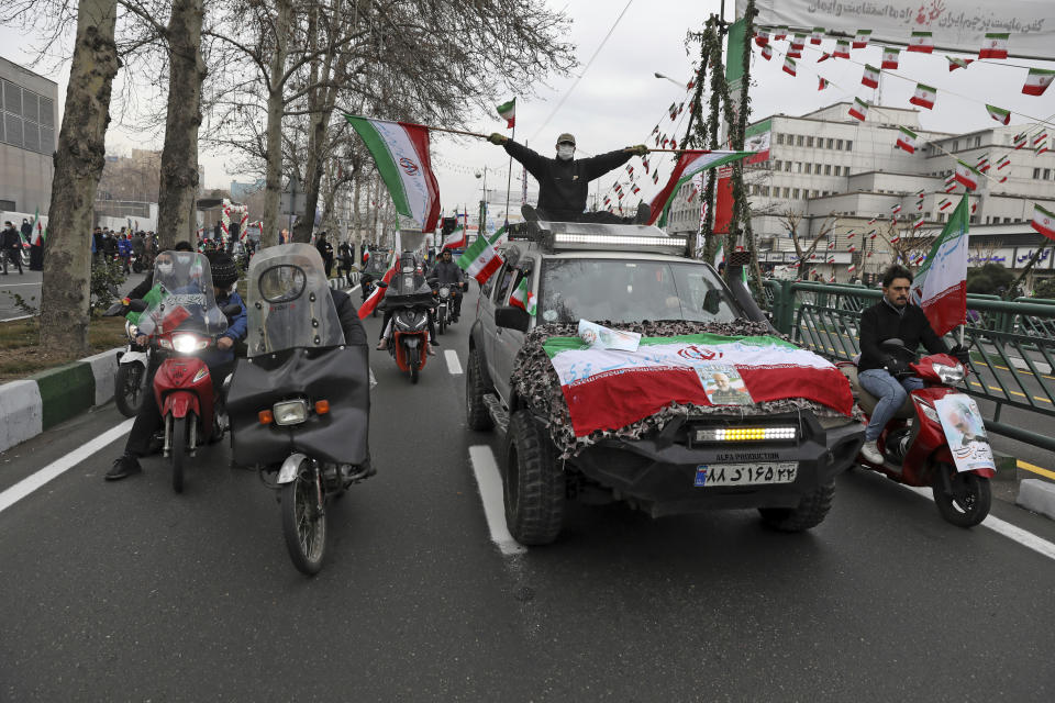 People parade with Iran's flags during the annual rally commemorating anniversary of1979 Islamic Revolution in Azadi (freedom) Sqaure in Tehran, Iran, Friday, Feb. 11, 2022. Thousands of cars and motorbikes paraded in the celebration, although fewer pedestrians were out for a second straight year due to concerns over the coronavirus pandemic. (AP Photo/Vahid Salemi)