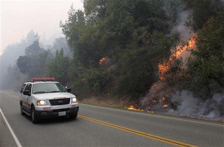 A wildfire burns next to Highway 1 in Big Sur, California, December 18, 2013. REUTERS/Michael Fiala