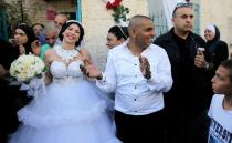 Groom Mahmoud Mansour, 26, (C) and his bride Maral Malka, 23, celebrate with friends and family before their wedding in Mahmoud's family house in Jaffa, south of Tel Aviv August 17, 2014. Israeli police on Sunday blocked more than 200 far-right Israeli protesters from rushing guests at the wedding of a Jewish woman and Muslim man as they shouted "death to the Arabs" in a sign of tensions stoked by the Gaza war. Picture taken August 17, 2014. To match MIDEAST-ISRAEL/WEDDING REUTERS/Ammar Awad