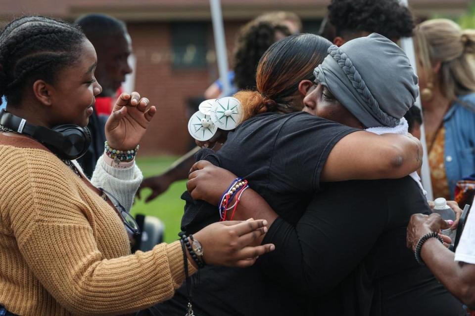 Hugs are given to Felicienne Kueviakoe, right, the mother of the children lost in the apartment fire Sunday night at Chapman Homes in Concord, NC.