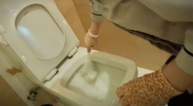 The cleaner then starts cleaning the toilet bowl with the same brush. Source: Pear Video