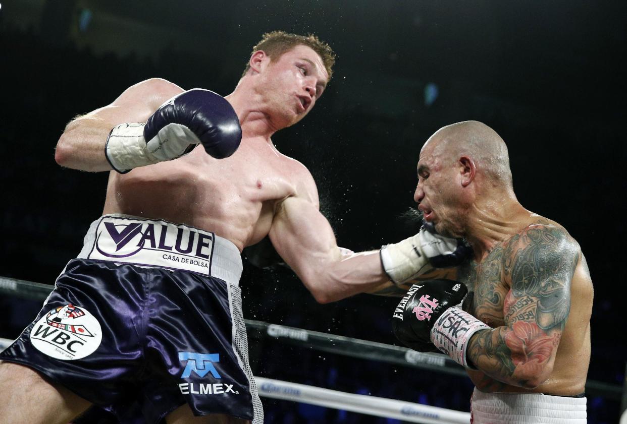 Miguel Cotto, a la derecha, de Puerto Rico, es golpeado por el mexicano Canelo Álvarez, of Mexico, durante un combate de peso mediano de WBC el sábado 21 de noviembre 2015, en Las Vegas. (AP Foto/John Locher)