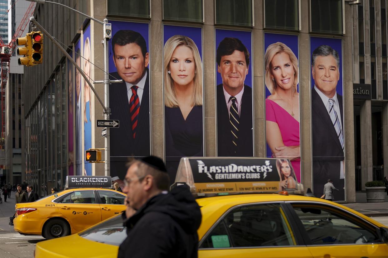 Traffic on Sixth Avenue passes by advertisements featuring Fox News personalities, including Bret Baier, Martha MacCallum, Tucker Carlson, Laura Ingraham, and Sean Hannity: Photo by Drew Angerer/Getty Images