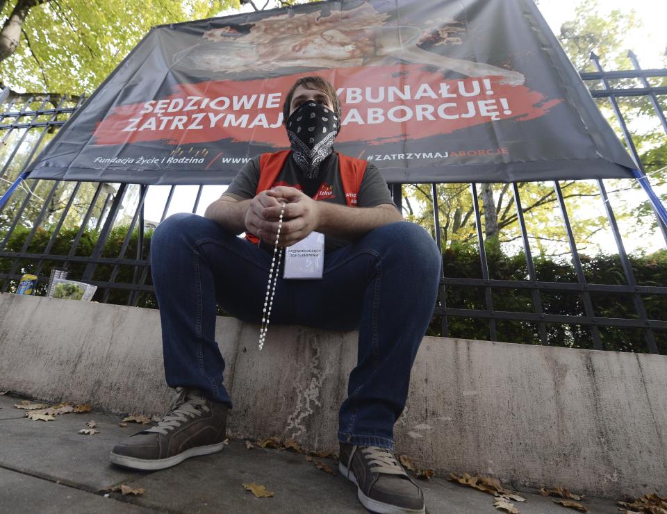 Anti-abortion activists attend a protest in front of Poland's constitutional court, in Warsaw, Poland, Thursday, Oct. 22, 2020. Poland’s top court has ruled that a law allowing abortion of fetuses with congenital defects is unconstitutional. The decision by the country’s Constitutional Court effectively bans terminating pregnancies in cases where birth defects are found and will further limit access to abortions in Poland. (AP Photo/Czarek Sokolowski)