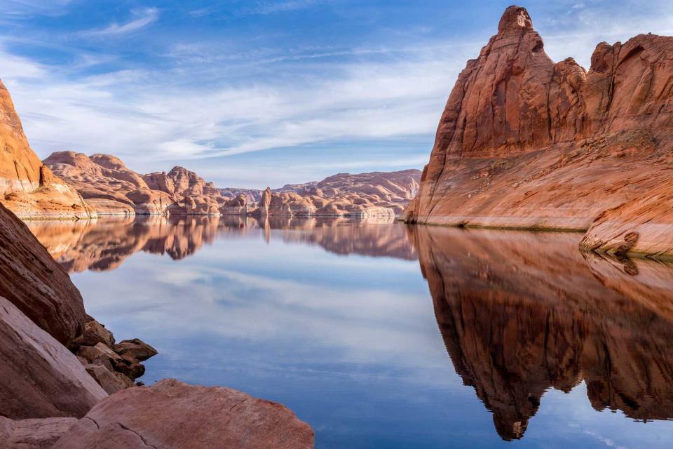 Red rock cliff reflection on water of Lake Powell