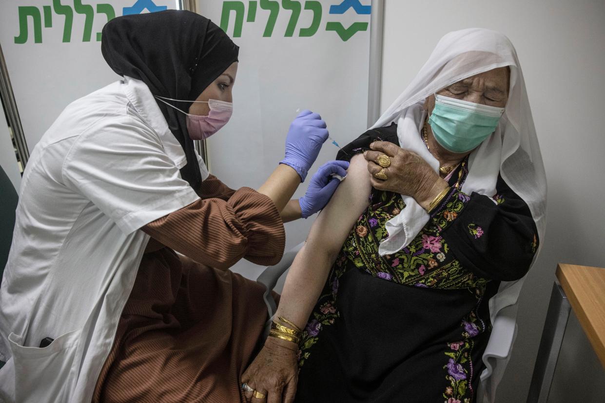 A Bedouin woman receives a Pfizer COVID-19 vaccine at a medical center in the Bedouin local council of Segev Shalom near the city of Beersheba, southern Israel, Wednesday, Dec. 30, 2020.