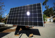 A solar installer carries a solar panel during an installation at a residential home in Scripps Ranch, San Diego, California, U.S. October 14, 2016. Picture taken October 14, 2016. REUTERS/Mike Blake