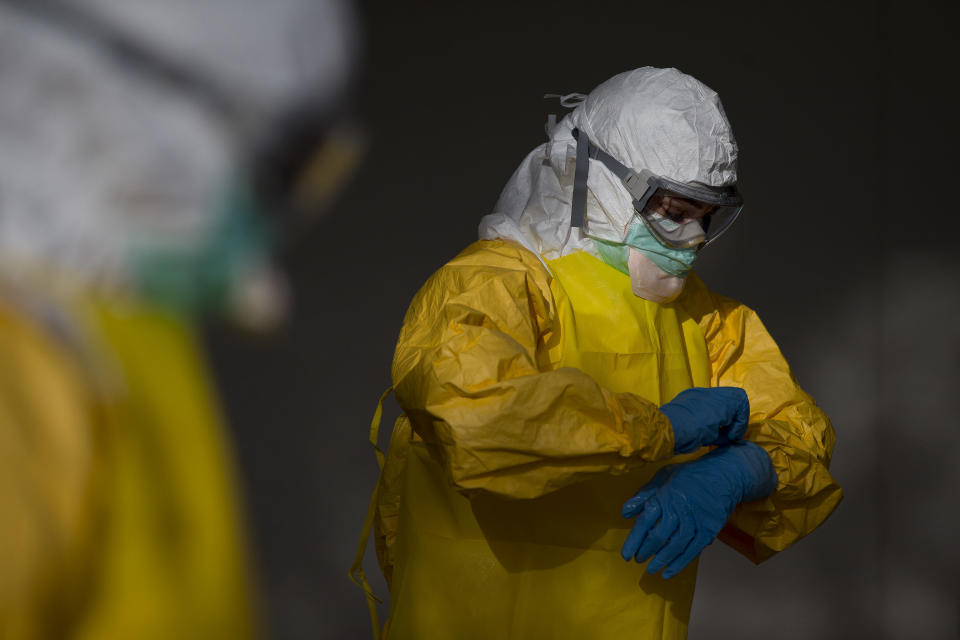 Licensed clinician Margaret Chilcott removes her outer gloves before disrobing and sanitizing on Monday, Oct. 6, 2014, in Anniston, Ala. The Centers for Disease Control and Prevention (CDC) has developed an introductory training course for licensed clinicians. According to the CDC, the course is to ensure that clinicians intending to provide medical care to patients with Ebola have sufficient knowledge of the disease. (AP Photo/Brynn Anderson)