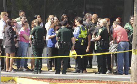 Parents and onlookers speak to police officers after a vehicle crashed into a child care center in Winter Park, Florida April 9, 2014. REUTERS/Stephen M. Dowell/Orlando Sentinel