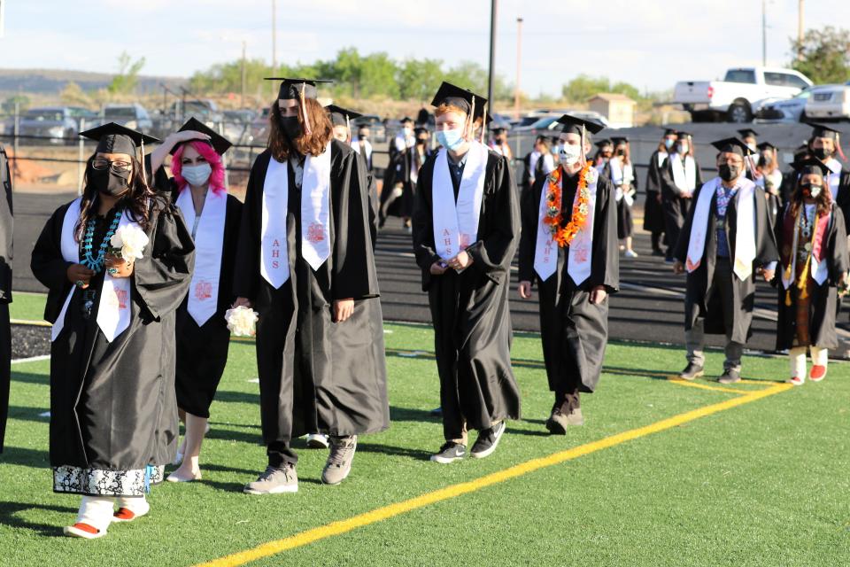 Aztec High School graduates walk during the processional on May 21, 2021 during the commencement ceremony at Fred Cook Memorial Stadium.