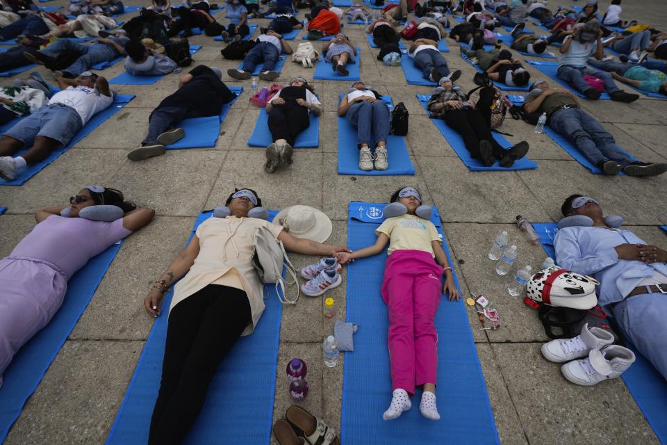 Lolling with bright blue mats, sleeping masks and travel pillows, people lie sprawled out at the base of the iconic Monument to the Revolution to take a nap, in Mexico City, Friday, March 15, 2024. Dubbed the “mass siesta,” the event was in commemoration of World Sleep Day. (AP Photo/Fernando Llano)
