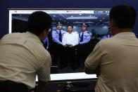 Men look at a screen displaying a picture of disgraced Chinese politician Bo Xilai standing trial on the website of a court's microblog, in Jinan, Shandong province September 22, 2013. The court sentenced former Chongqing Municipality Communist Party Secretary Bo to life in jail on Sunday after finding him guilty on all counts following his dramatic five-day trial last month on charges of corruption, taking bribes and abuse of power.REUTERS/Aly Song (CHINA - Tags: POLITICS CRIME LAW)