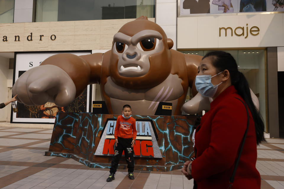 A child poses for photos near a movie advertisement along a retail street in Beijing on Friday, April 9, 2021. China’s economic growth surged to 18.3% over a year earlier in the first quarter of this year as factory and consumer activity recovered from the coronavirus pandemic. (AP Photo/Ng Han Guan)