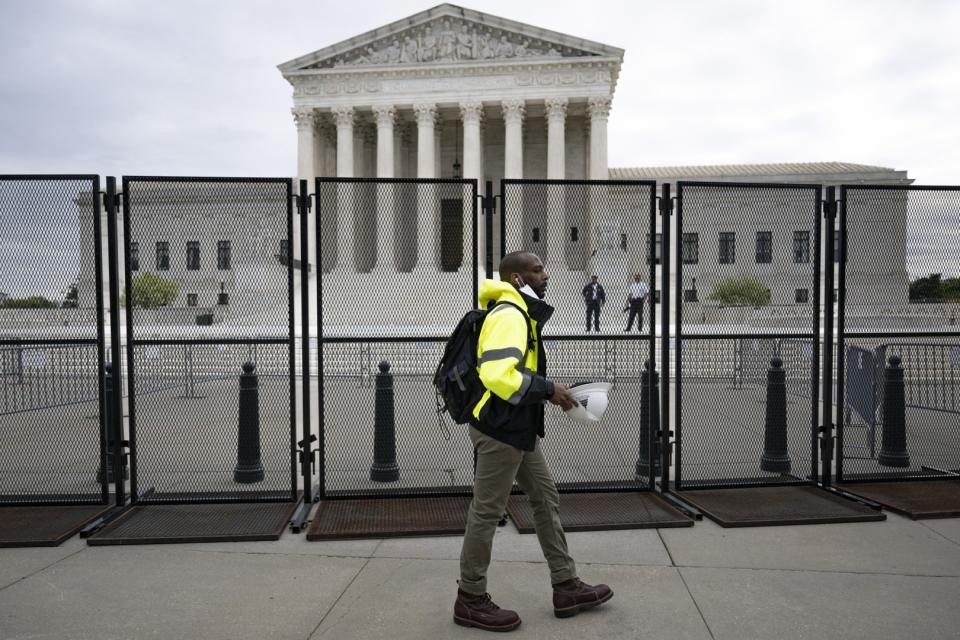 <span>Un trabajador pasa junto a una valla infranqueable que rodea la Corte Suprema de Estados Unidos en Washington, el 5 de mayo de 2022</span><div><span>Jim WATSON</span><span>AFP</span></div>