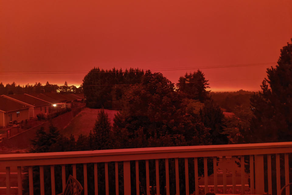 This photo taken from the home of Russ Casler in Salem, Ore., shows the smoke-darkened sky well before sunset at around 5 p.m., Tuesday, Sept. 8, 2020. Strong winds and high temperatures continued to fuel catastrophic fires in many parts of Oregon on Wednesday, forcing thousands of people to flee from their homes and making for poor air quality throughout the West. Huge wildfires also continued to grow in neighboring Washington state. (Russ Casler via AP)