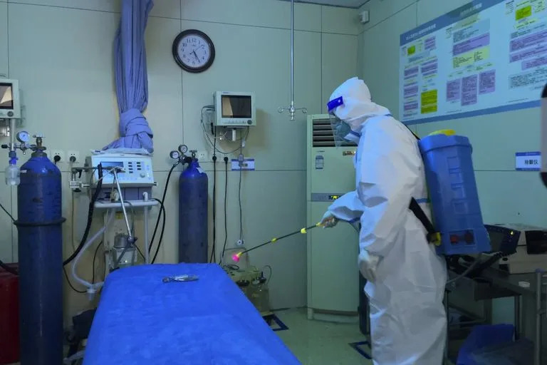Un trabajador del hospital con equipo de protección desinfecta la sala de un servicio de emergencias del Hospital Aeroespacial de la Nueva Área de Baigou, en Baigou, en la provincia septentrional china de Hebei, el jueves 22 de diciembre de 2022. 