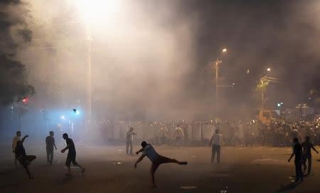 Demonstrators who had gathered in a show of support for gunmen holding several hostages in a police station, clash with riot police in Yerevan, Armenia, July 20, 2016. REUTERS/Vahram Baghdasaryan/Photolure