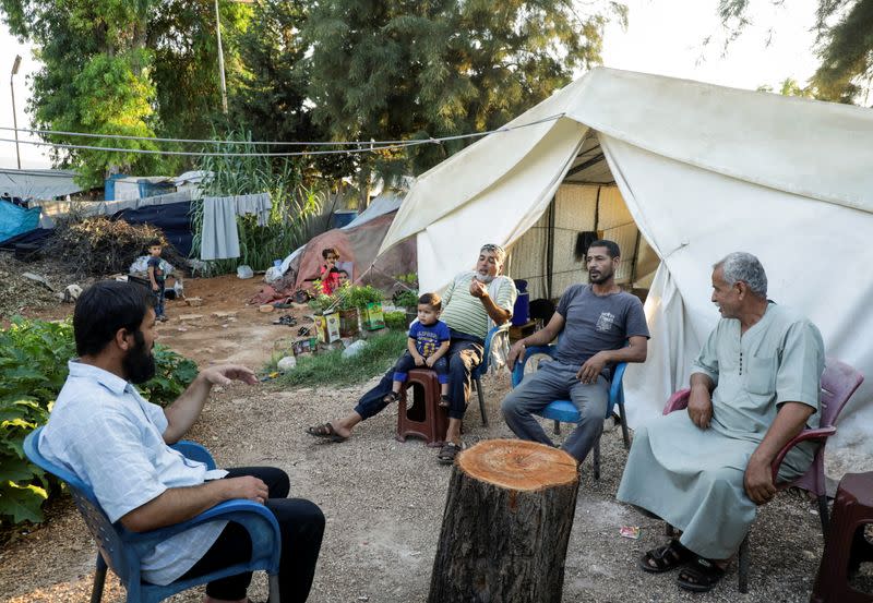 Hossam Kaheil sits with his neighbors at a camp for internally displaced people in Idlib