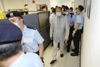 Hong Kong media tycoon Jimmy Lai, center, is escorted by police inside Apple Daily headquarters in Hong Kong Monday, Aug. 10, 2020. Hong Kong police arrested Lai and raided the publisher's headquarters Monday in the highest-profile use yet of the new national security law Beijing imposed on the city in June. (Apple Daily via AP)
